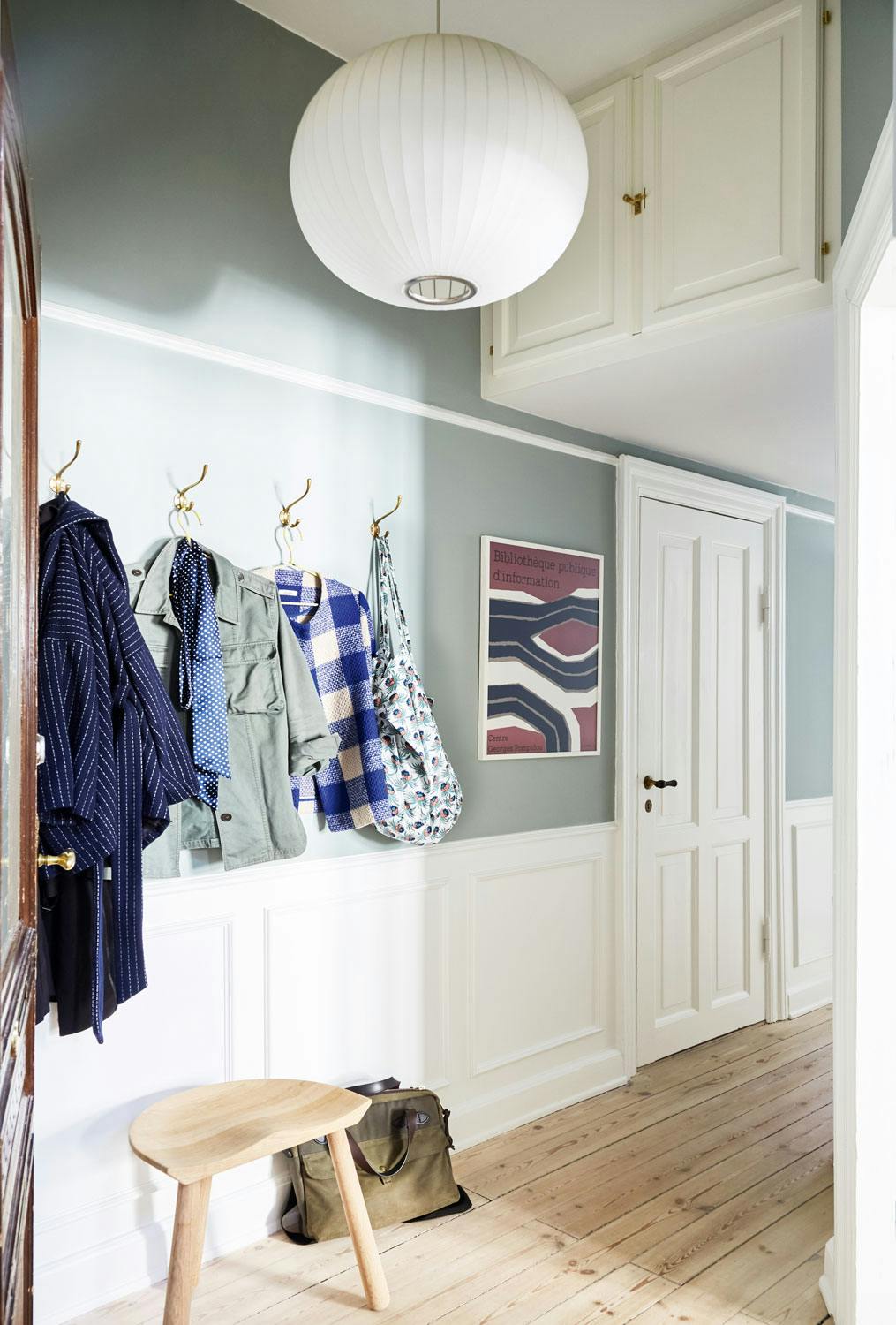 Elegant resultat entré malt i Minty Breeze fra Jotun med hvitt brystningspanel og designlampe